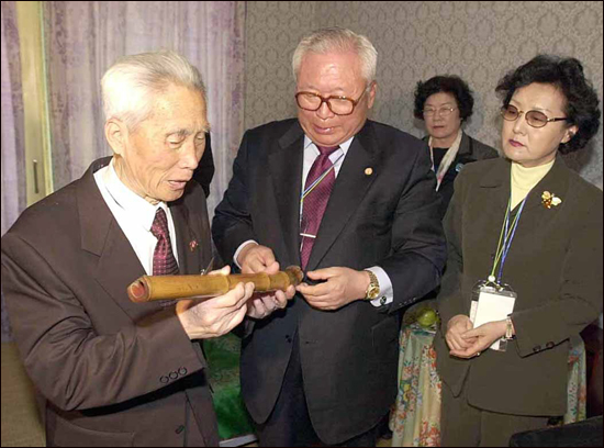 2002년 5월 2일 금강산여관 개별상봉에서 민주평통 김민하 부의장 가족이 형님 김성하씨에게 피리를 선물하고 있다.