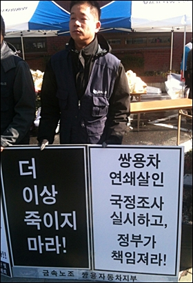 1일 오전 해고노동자의 연이은 죽음에 대한 해결을 촉구하는 기자회견에서 쌍용자동차 노동자가 "더 이상 죽이지 마라"는 호소가 담긴 피켓을 들고 있다.