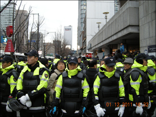 기자 회견에 사용할 마이크를 막고 있는 경찰 경찰이 기자회견에 사용하려던 마이크를 막아 내놓지 않고 있다.