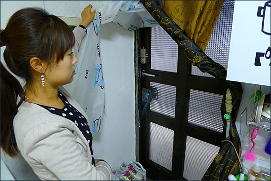 1일 오후 서울 은평구 신사동의 한 주택에서 김현아씨가 정상길 두꺼비하우징 팀장에게 웃풍이 거센 낡은 현관문을 보여주고 있다.