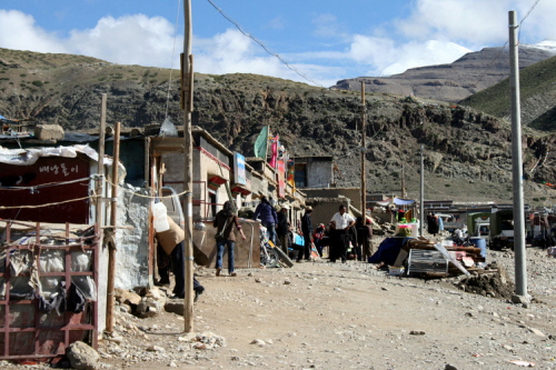 자신의 터전을 빼앗기고 비만 피할 수 있는 허름한 공간에서 살고 있는 티베트인들