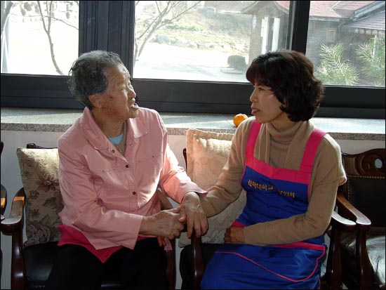 나눔의 집 할머니가 자원봉사하는 삼육대 부인회 회원의 손을 잡고 고마워하고 있다.