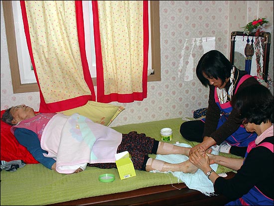 삼육대 부인회 회원들이 나눔의 집 할머니들에게 발마사지 자원봉사를 하고 있다.
