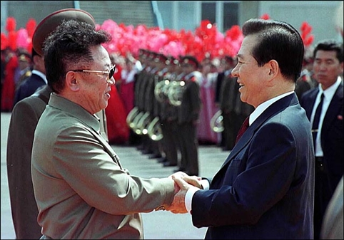 2000년 6월 13일 오전 평양 순안공항에 도착한 김대중 대통령과 김정일 국방위원장이 밝은 표정으로 악수를 하고 있다.
