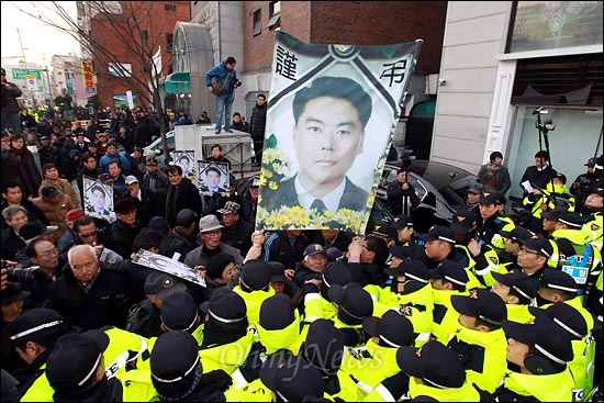 어버이연합 회원들이 고인의 영정을 앞세우고 중국대사관을 향해 행진을 시도하며 경찰과 격렬한 몸싸움을 벌이고 있다.