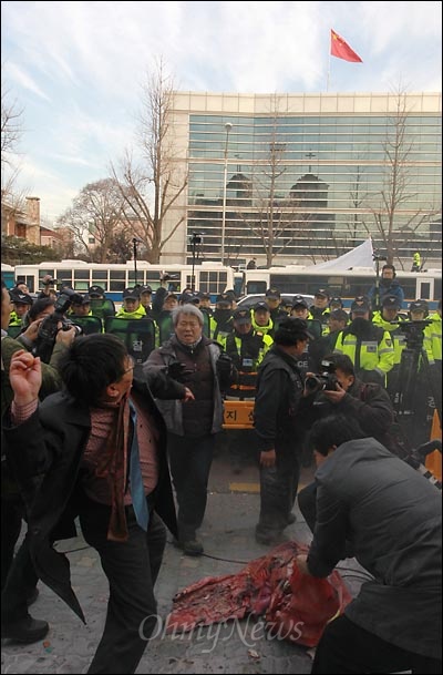 어버이연합 회원들이 달걀 수십개를 중국대사관을 향해 던지고 있다.
