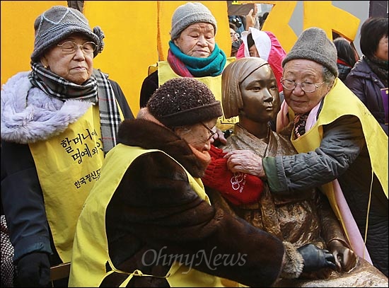 14일 오후 서울 종로구 주한 일본대사관 앞에서 열린 '제1000차 일본군 위안부 문제 해결을 위한 정기 수요집회'에서 위안부 피해 김순옥(90, 사진 맨 왼쪽 시계방향), 박옥선(88), 길원옥(84), 김복동(85)할머니들이 시민사회의 모금으로 건립한 평화비를 안아보고 있다.
평화비는 한복을 입고 손을 무릎 위에 모은 채 작은 의자에 앉아 있는 10대 소녀의 모습을 형상화한 높이 130cm의 비로 할머니들이 항상 시위하던 일본대사관 정문에서 불과 15m 떨어진 건너편 인도에 설치됐다.