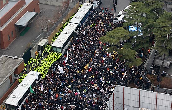 지난해 12월 '제1000차 수요집회'에서 참가자들이 일본 정부의 사죄를 요구하고 있는 가운데, 수많은 경찰관들이 일본대사관 앞을 지키고 있다.