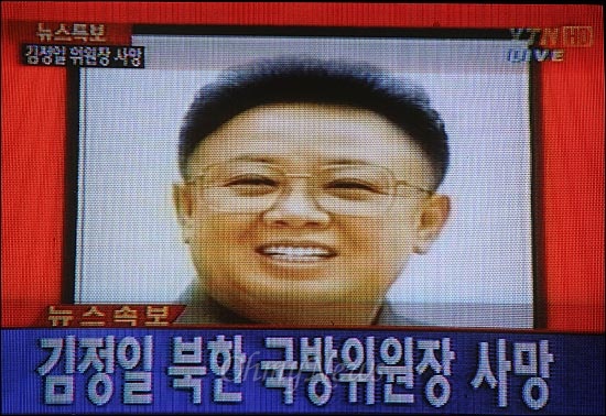 북한 조선중앙TV가 지난 17일 김정일 국방위원장이 열차에서 현지지도 중 과로로 사망했다고 보도한 가운데, 19일 YTN이 김 국방위원장의 사망 긴급뉴스를 보도하고 있다. 