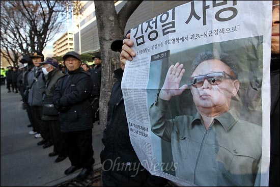 어버이연합 "김정일 사망 환영" 김정일 국방위원장 사망 소식이 전해진 19일 오후 광화문 KT건물 앞에서 '김정일 사망 환영 기자회견'을 개최한 어버이연합 회원들이 '김정일 사망' 기사를 실은 한 일간지 호외에서 김정일 얼굴 사진에 구멍을 뚫어 훼손한 뒤 들고 있다.