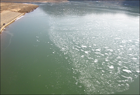 상주보 상류 부분. 강물이 녹색 빛을 보이고 있고 유속이 느려져 얼음이 얼고 있다. 유속이 느려지면 강한 햇빛에 의해 조류가 활성화 돼 녹조현상이 발생할 수 있다.