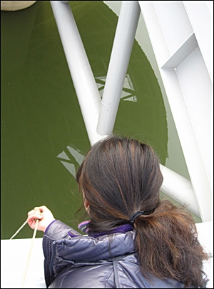 지난해 12월 녹조가 의심되는 강정고령보에서 '생명의 강 연구단'이 수질 검사를 위해 채수를 하는 장면. 강물이 짙은 녹색을 띠고 있다.