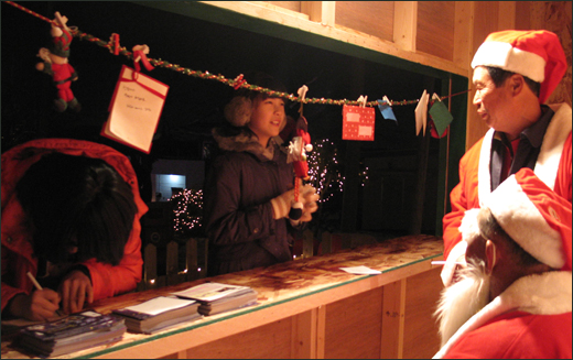 크리스마스 축제 참가자가 이슬촌 소망우체국에서 소망엽서에 소원을 쓰고 있다. 지난 2009년 축제 때 모습이다.