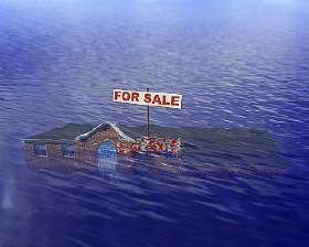 바닷물에 떠내려가는 주택 세일 간판이 부동산 시장의 어려움을 상징적으로 보여주고 있다. 
