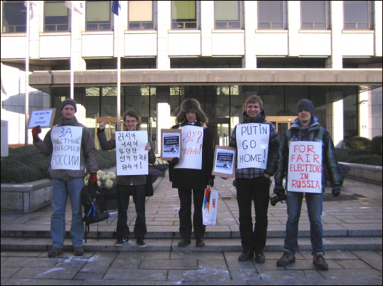 학생, 직장인, 기자 등 다양한 배경의 국내 체류 러시아인들이 한국언론재단 건물 앞에서 3개국어로 쓰여진 피켓을 보이고 있다.