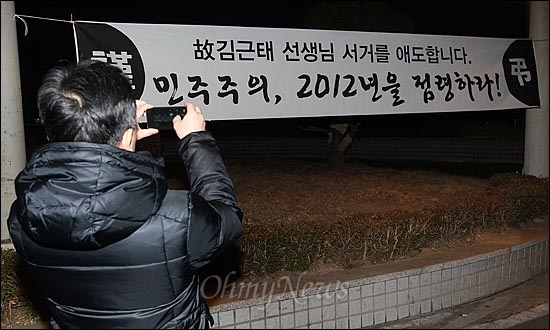 고 김근태 민주통합당 상임고문이 64세로 별세한 가운데, 31일 오후 서울 종로구 서울대병원 장례식장 앞에 고인을 추모하는 대형현수막이 걸려있자, 한 시민이 휴대폰 카메라로 촬영하고 있다.