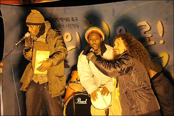 강정을 지키는 다국적 연합군. 강정에 상주하는 뱅자맹 모네(맨 오른쪽)와 그의 세네갈 친구들이 노래를 부르고 있다.