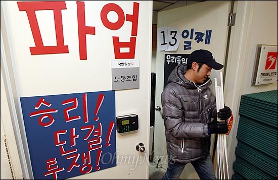 국민일보 노조가 지난 12월 23일부터 총파업을 벌이고 있는 가운데, 4일 오전 서울 여의도 사옥 노조사무실에서 한 조합원이 거리 선전전을 하기 위해 피켓을 들고 사무실을 나서고 있다.