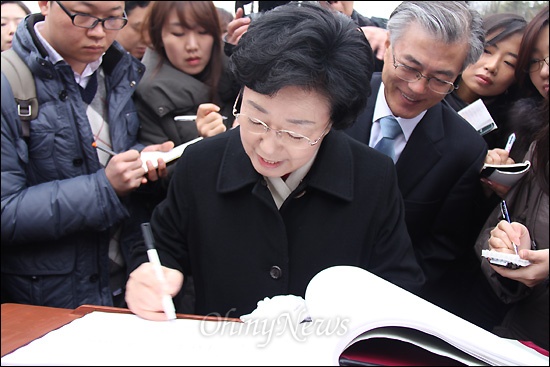 한명숙 대표 등 민주통합당 지도부가 18일 오전 김해 봉하마을 고 노무현 전 대통령 묘역을 참배했다. 사진은 한명숙 대표가 방명록에 기록하는 동안 문재인 이사장이 보며 웃고 있는 모습.