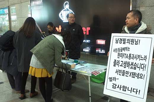 제215차 수원촛불이 진행된 18일 밤 시민 박정근씨가 손팻말을 들고 서 있다. 