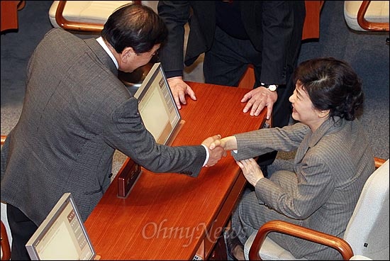 박근혜 한나라당 비상대책위원장이 19일 오후 서울 여의도 국회 본회의장에서 이재오 의원과 인사를 나누고 있다.