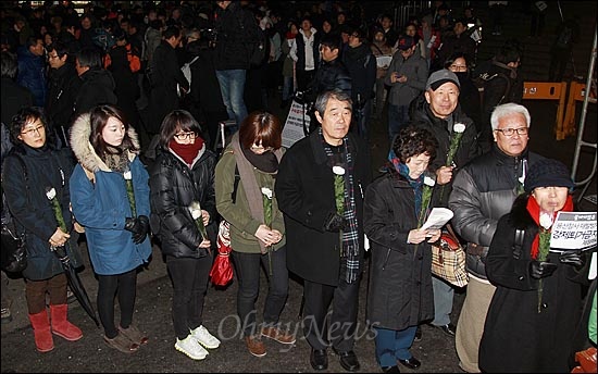  19일 오후 서울 중구 서울역 광장에서 열린 '용산참사 3주기 추모대회'에서 수많은 시민들이 고인들의 넋을 위로하며 헌화하기 위해 줄을 서서 기다리고 있다.