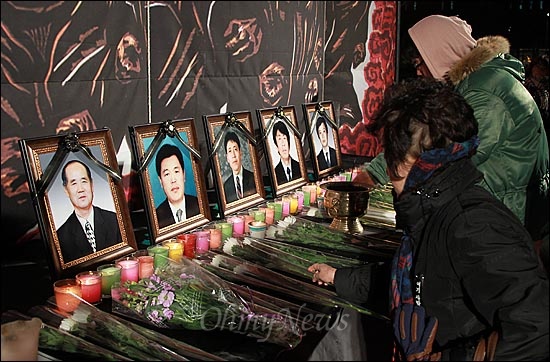 19일 오후 서울 중구 서울역 광장에서 열린 '용산참사 3주기 추모대회'에서 참가자들이 고인들의 넋을 기리며 헌화하고 있다.