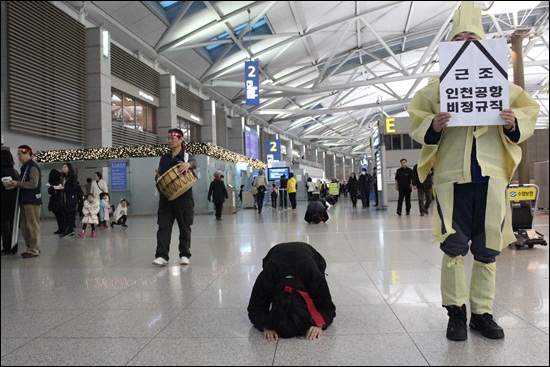 인천공항 세관에서 해고된 비정규직 노동자들이 지난 17일 오전 8시 인천공항 3층 입국장에서 7보1배를 하고 있다.