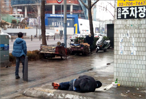 지난 21일 서울역 거리에서 한 노숙인이 잠을 자고 있다.