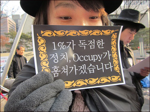 'Occupy 여의도!'에서 괴도루팡 복장을 한 학생이 피켓을 들고 있습니다.
