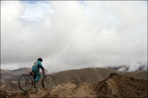 나에게 따라오라며 손짓을 하고 자전거를 몰고 가는 티베트 아이. 