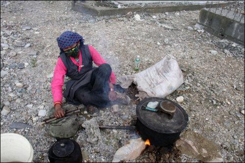 동물 배설물을 태워 물을 끊이고 있는 티베트 여인. 아무도 없는 곳에서 왜 혼자 물을 끓이고 있을까?