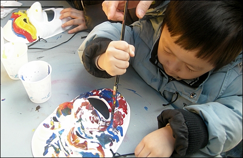 제법 진지한 표정으로 탈에 색칠하고 있는 다섯 살배기 김재형군
