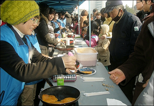 자원봉사자들이 김치전을 나눠주고 있다. 이날 먹는 음식은 모두 ‘꽁자’!
