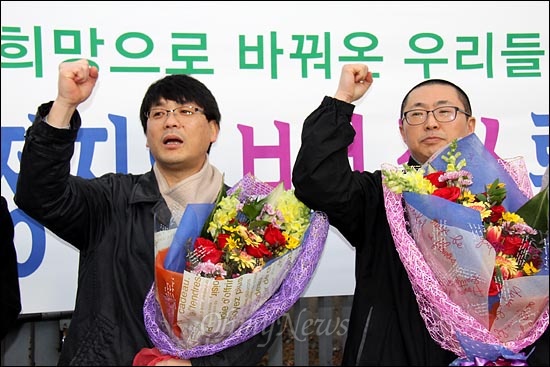 '희망버스'를 기획했던 송경동 시인과 정진우씨가 구속 87일만인 9일 보석 결정을 받고서 부산구치소를 나온 뒤 꽃다발을 받고 구호를 외치고 있다.
