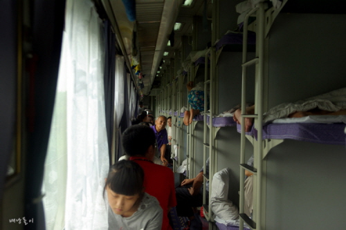 복도에서 각자의 기차 여행을 즐기고 있는 중국 사람들.