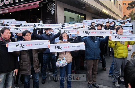  13일 오후 MBC 노동조합원들이 서울 서초구 방배동 서래마을 인근에서 김재철 MBC 사장을 찾는 집회를 열며 펼침막을 들어보이고 있다. 
 
