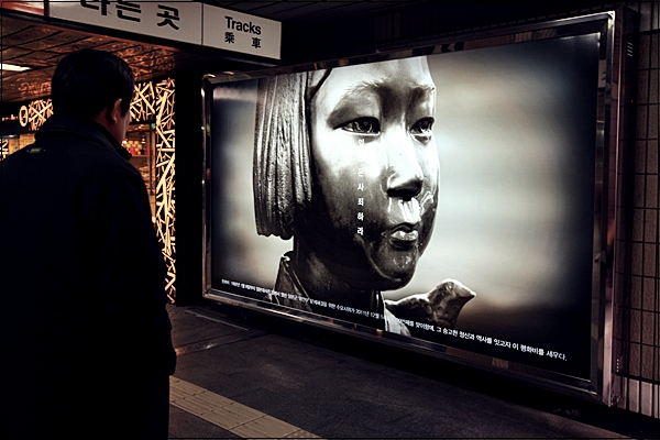 한시민이 서울 지하철 3호선 안국역 4번출구 안쪽에 '평화비'를 소재로 한 사진광고를 유심히 바라보고 있다.
