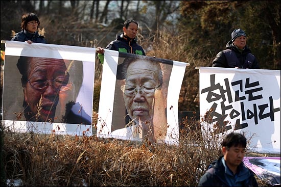  추모식이 열리는 동안 고 이소선 여사의 묘소 주위에는 고인의 생전 모습이 담긴 사진현수막을 든 비정규노동자들이 둘러 서 있다.