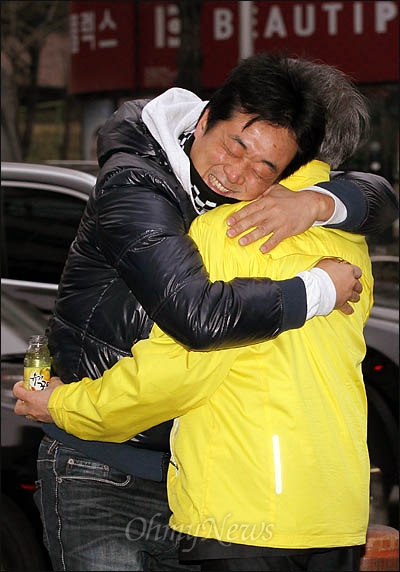 22일 부산 사상구 신모라사거리에서 출근인사를 하는 문재인 민주통합당 상임고문에게 꿀차를 선물한 시민이 응원메시지를 전하며 와락 껴안고 있다. 