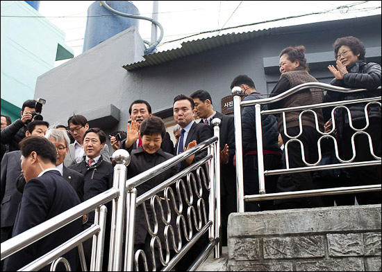 24일 부산 감천동 문화마을을 방문한 박근혜 새누리당 비상대책위원장이 계단을 내려오며 동네주민들의 환호에 손을 들어 답하고 있다.