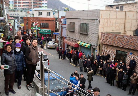 24일 오후 부산 감천동 문화마을 주민들이 방문한 박근혜 새누리당 비상대책위원장이 나타나길 기다리며 서 있다.