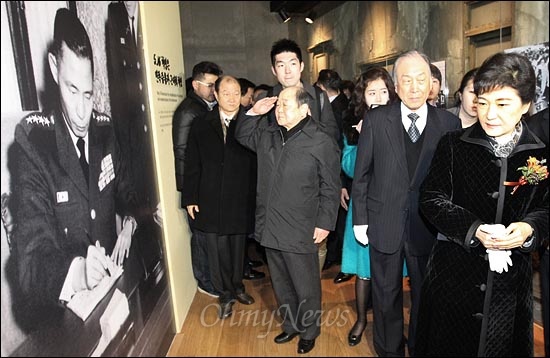 박근혜 새누리당 비대위원장이 21일 오전 개관한 서울 상암동 '박정희대통령기념·도서관'을 둘러보고 있다. '5.16쿠데타'를 '5.16혁명'으로 미화한 전시장에 내걸린 사진을 향해 한 관람객이 거수경례를 하고 있다.