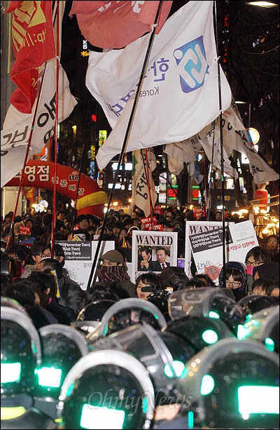 한미FTA 반대집회 참가자들이 25일 저녁 서울 명동 상가일대를 돌며 행진을 벌이다 경찰에 막혀 대치하고 있다.