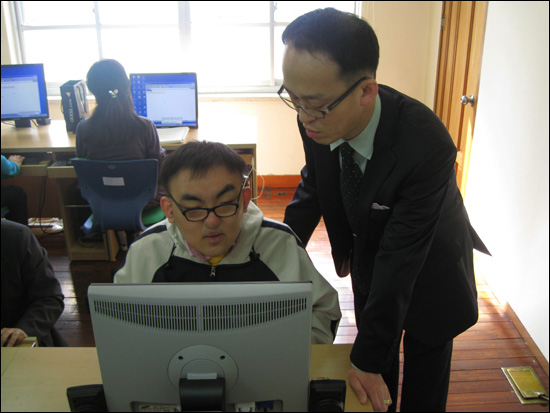 학생 앞에서 컴퓨터를 가르치고 있는 모습(오른쪽 문성준씨)