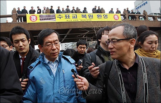 박원순 서울시장이 최병성 목사(오른쪽) 등 외부 전문가들과 함께 청계천을 둘러보고 있다. 뒷편에 지역 상인들이 내건 '수표교 복원 환영'이란 펼침막이 보인다.