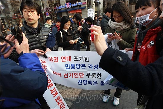 3일 오후 서울 청계광장에서 열린 '한미FTA 폐기 국민승리 촛불대회'에 참석한 일부 시민들이 4.11총선 야권연대를 촉구하며 민주통합당 한명숙 대표를 비난하는 현수막을 들고 있자, 선관위 직원들이 선거법 위반이라며 제지하고 있다.