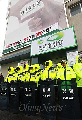  민주통합당이 공천심사로 내홍을 겪고 있는 가운데, 5일 오후 서울 영등포구 민주통합당사에서 경찰들이 공천탈락에 항의하는 지지자들을 저지하기 위해 배치되어 있다.