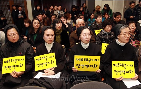  7일 오전 서울 중구 프레스센터 국제회의장에서 열린 '제주해군기지 건설 중단과 평화적 해결 촉구 비상시국회의'에서 수녀들이 '제주해군기지 전면 백지화'가 적힌 손피켓을 들고 있다.