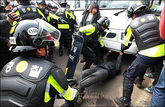 지난 3월 9일 오전 제주도 서귀포시 강정마을 해군기지 공사 현장 앞에서 해군기지 건설을 반대하는 목사와 신부, 활동가들이 공사현장 기습 점거시위를 벌이다가 경찰들에게 강제연행되자, 마을주민이 강제연행을 규탄하며 호송차량의 이동을 막고 있다.   